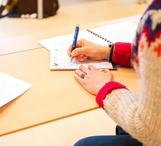 Woman Holding Blue Pen Writing on Paper